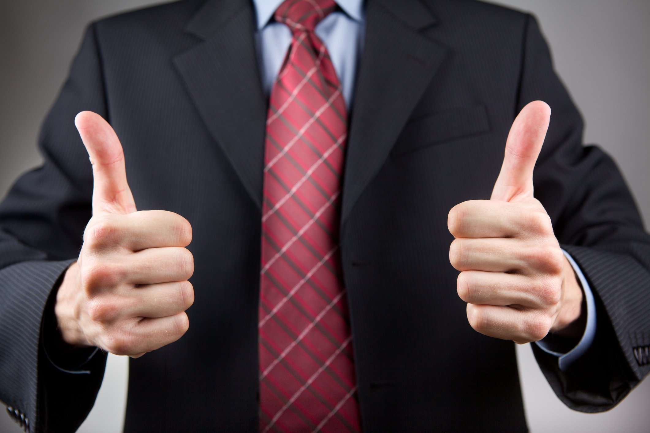 Man in suit showing two thumbs-up.