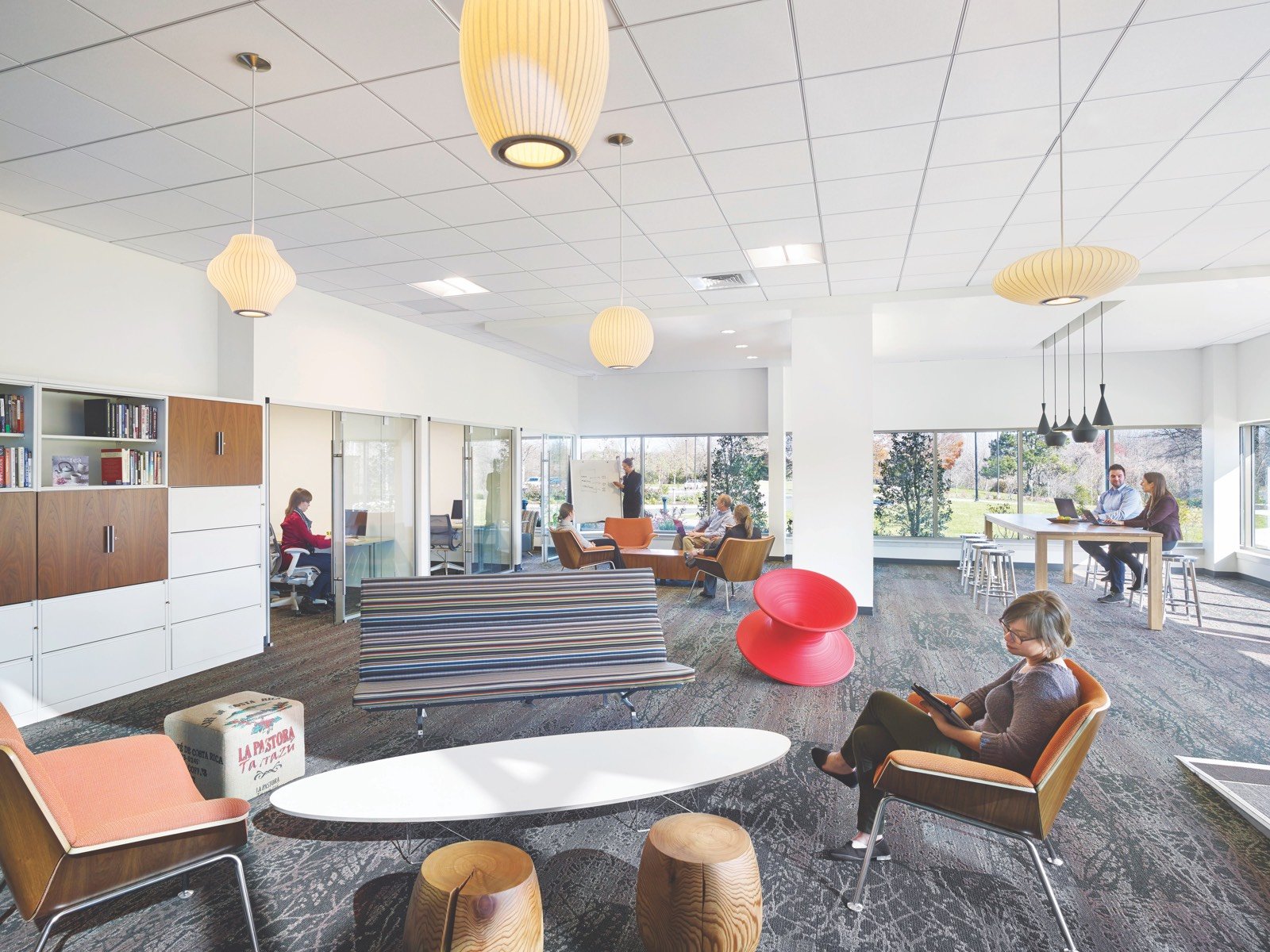 A woman works in a spacious, contemporary office lounge.