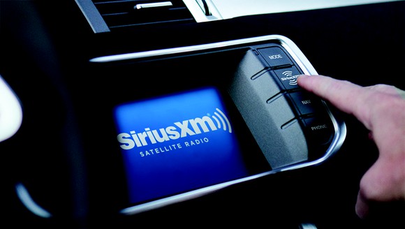 A person using an in-car Sirius XM interface. 