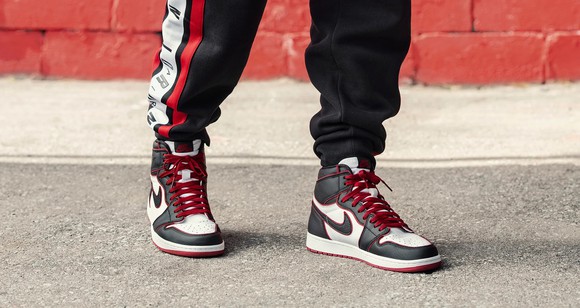 A person wearing Nike Air Jordan 1 High OG shoes.