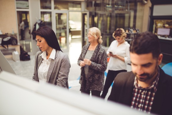 People in line at a bank to withdraw money from the ATM.