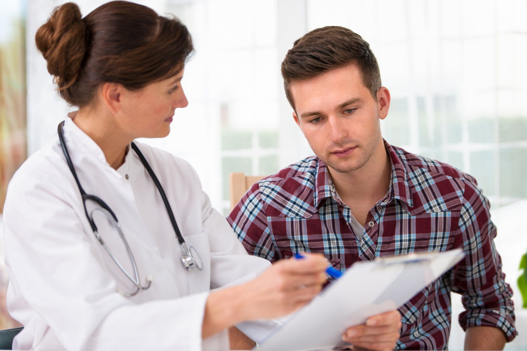 Doctor reviewing document with man