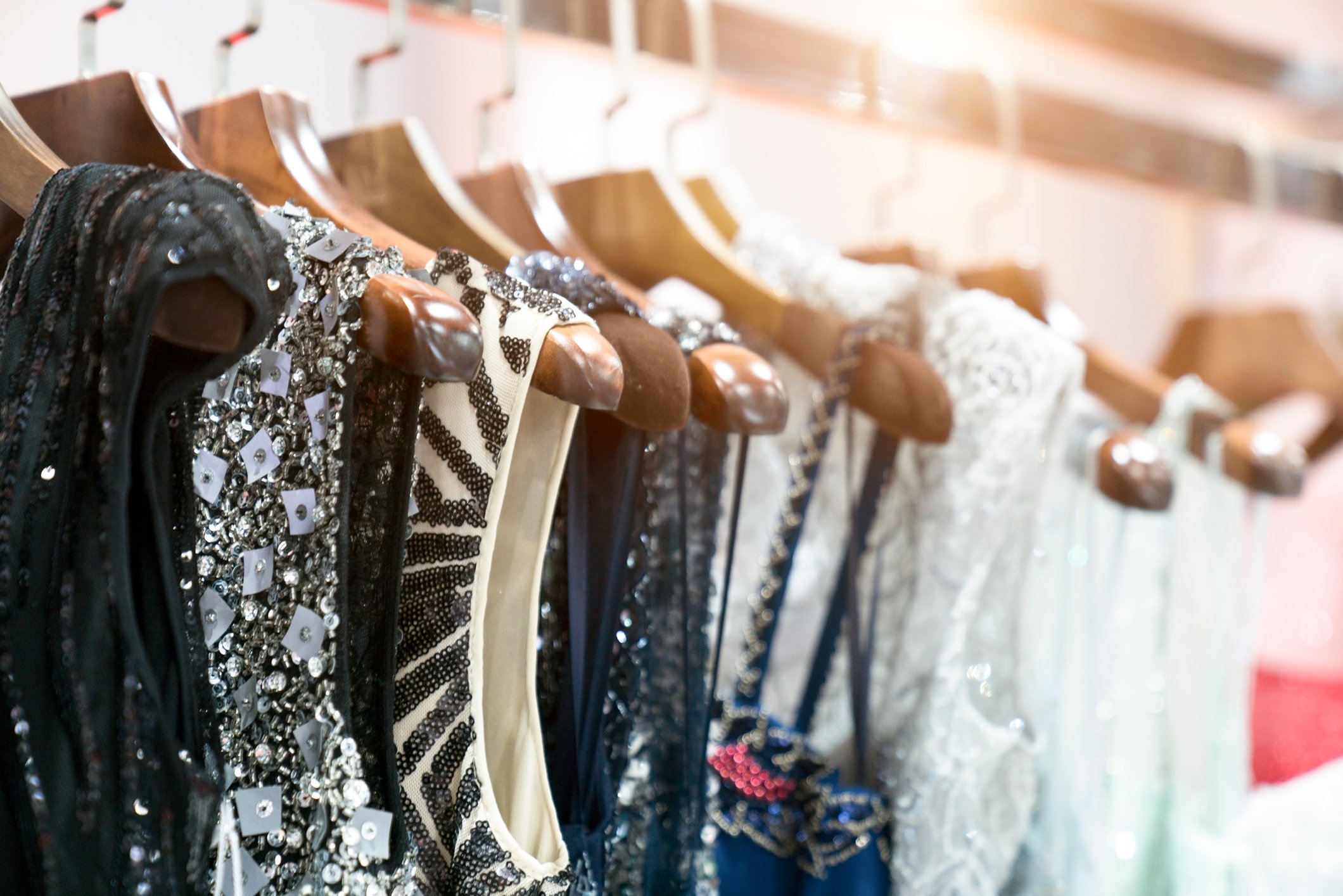 Sequined dresses, in black and white, on hangers in a store