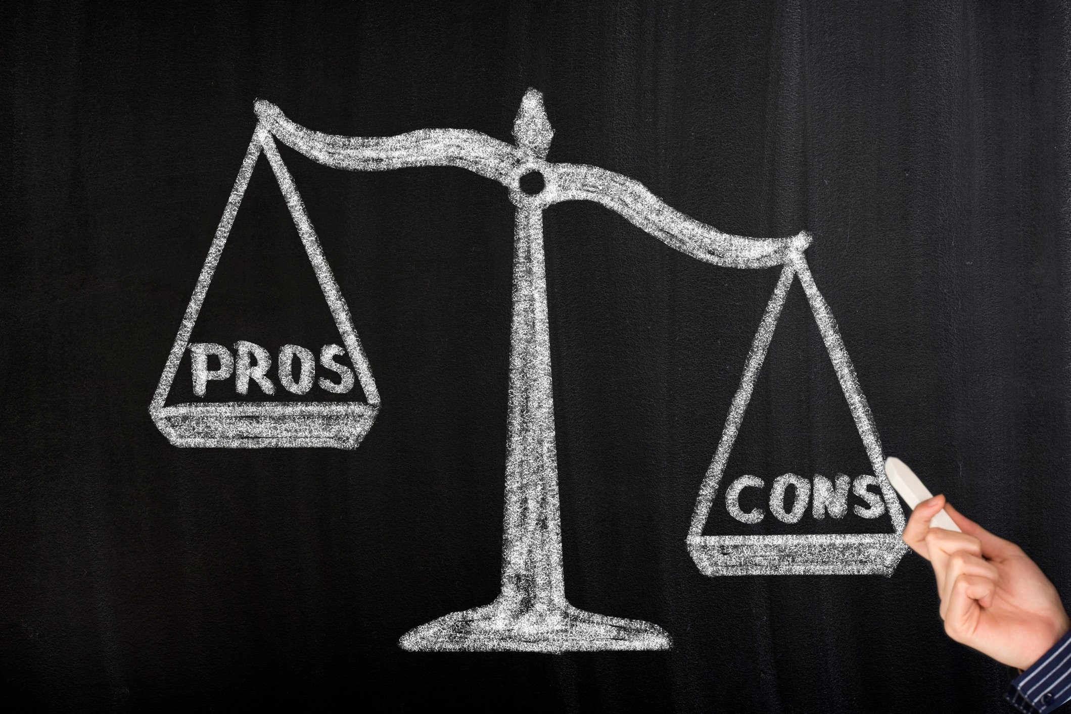 A chalk picture of pros being weighed against cons on a scale