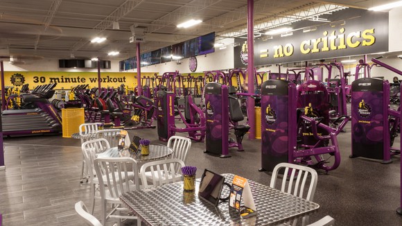 The inside of a Planet Fitness location with exercise machines and a seating area