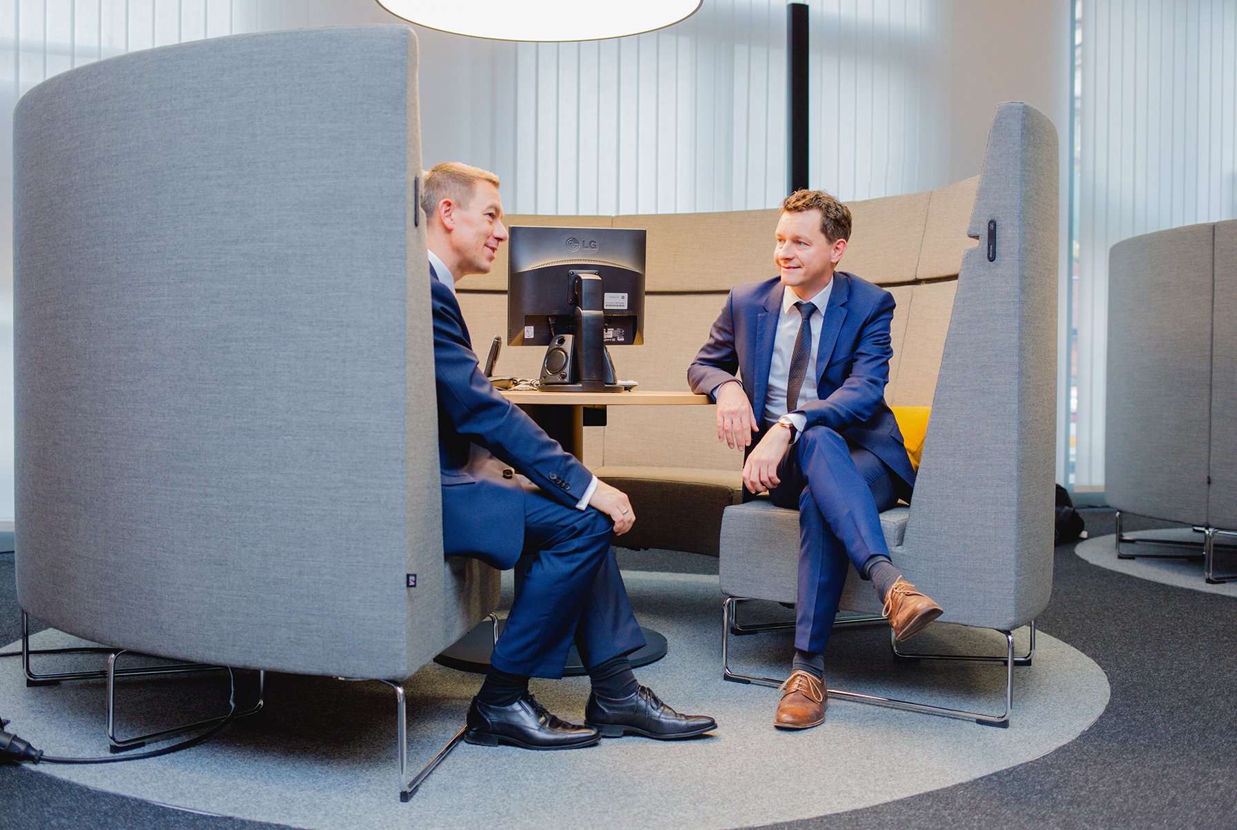 Two businessmen having a discussion inside a bank branch.