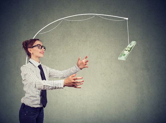 A woman chases money on a fishing rod.