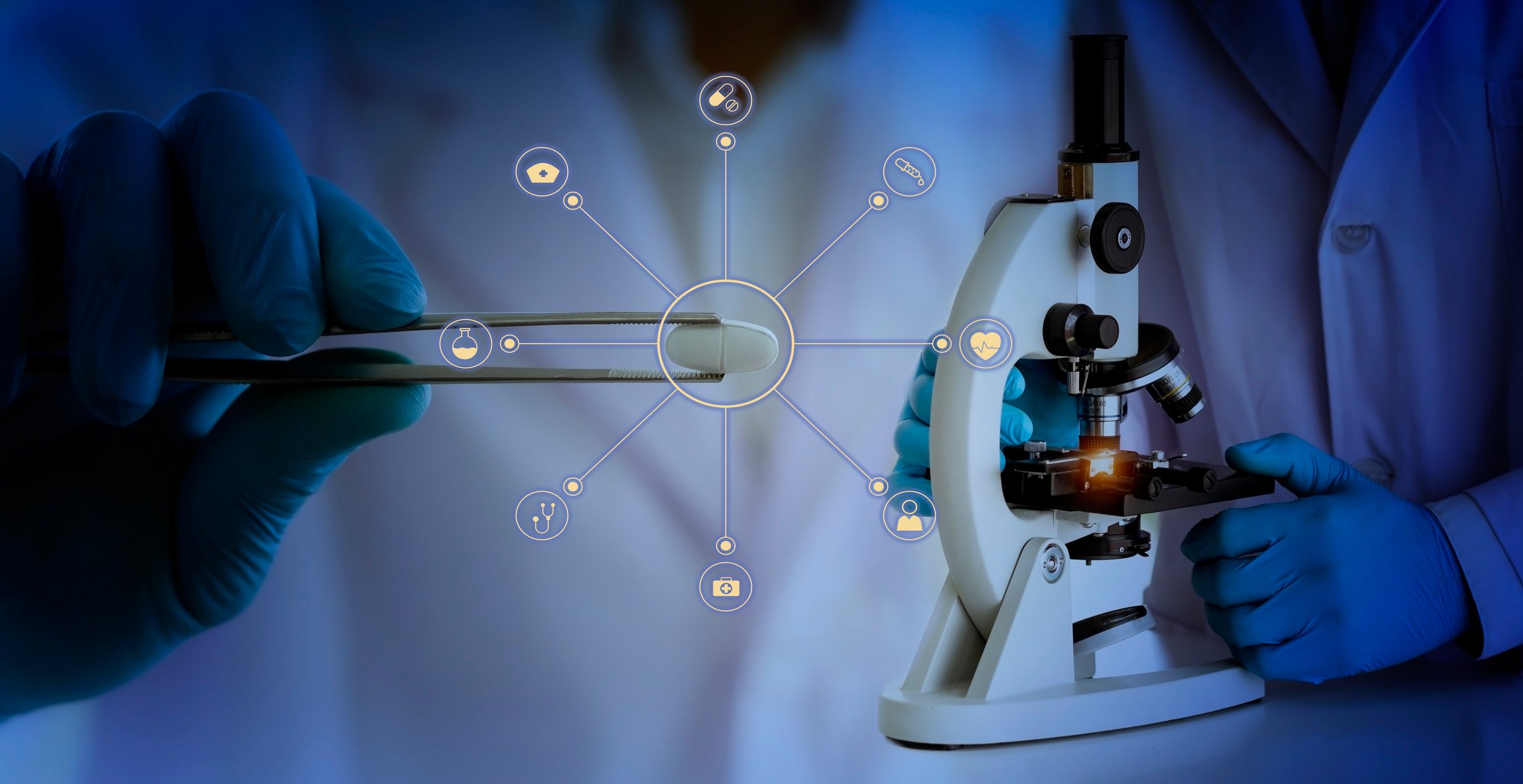 Hand holding tweezers with pill and another scientist holding a microscope.