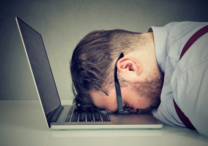 Man planting face on laptop