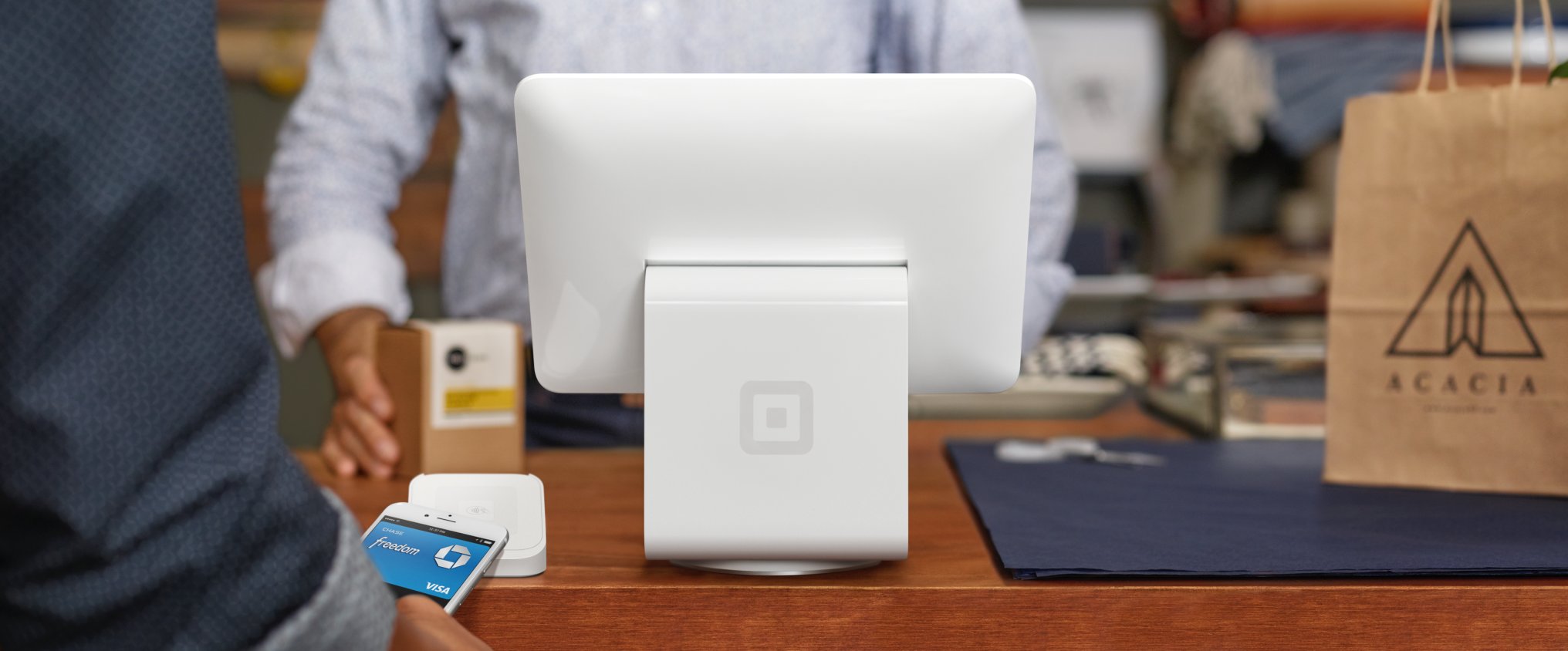 A customer checking out with Square's digital register and card reader in a store.