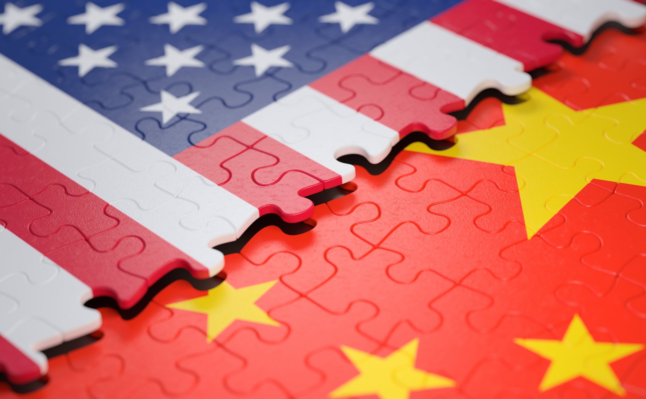 Two overlapping jigsaw puzzles of the American and Chinese flags.