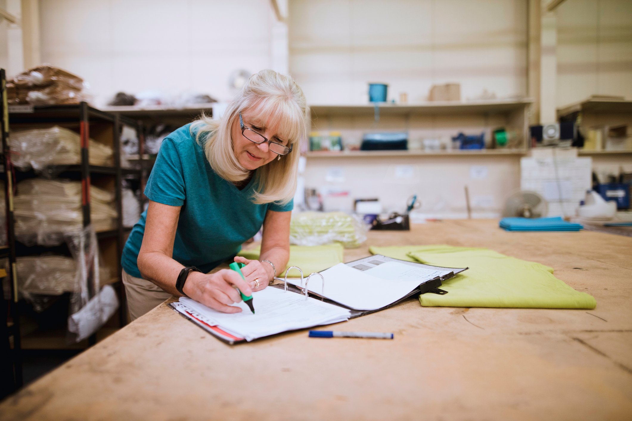 Older woman doing paperwork in a factory