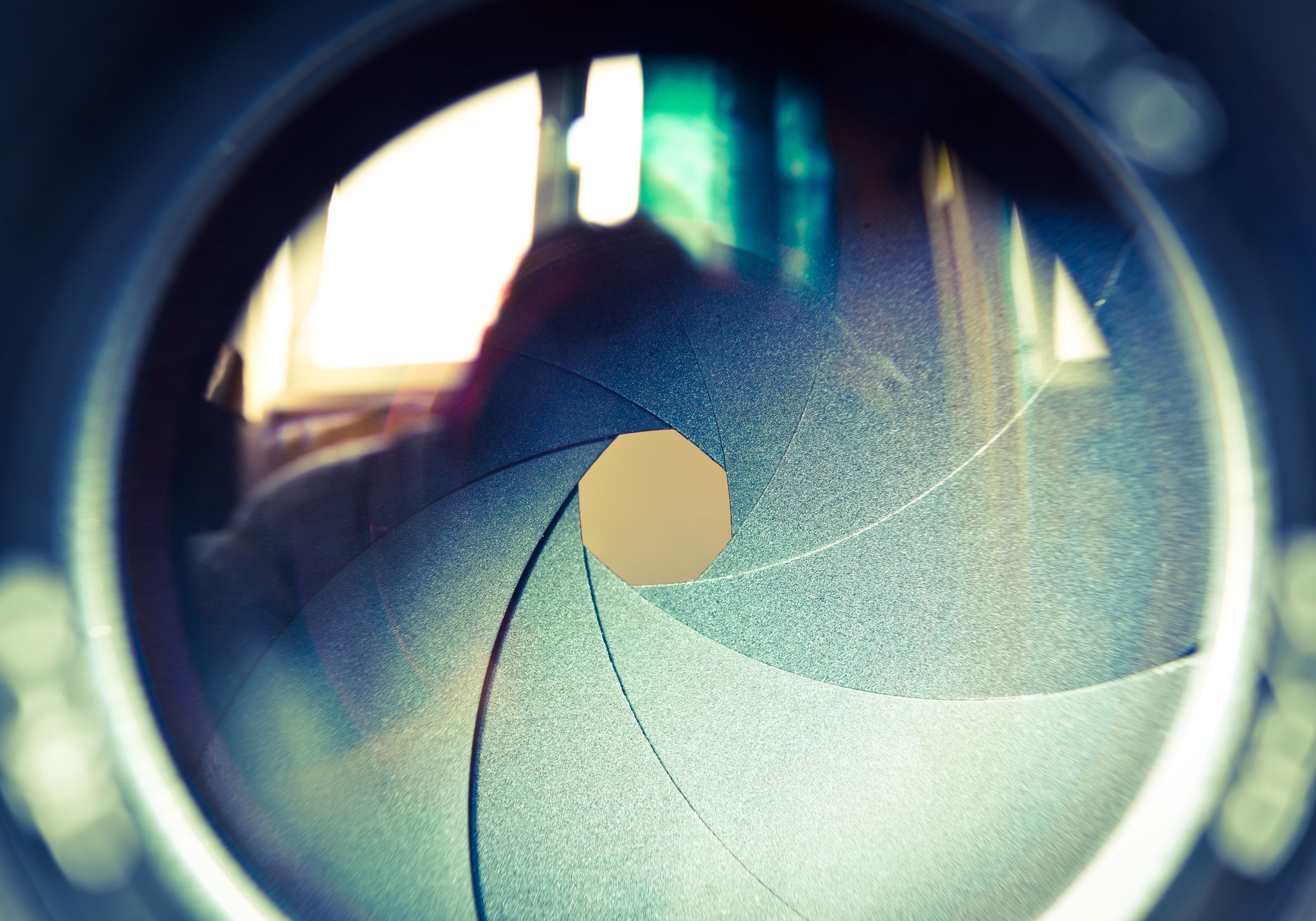 An up-close picture of a camera aperture slightly opened.