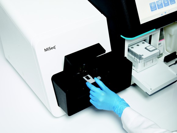 Scientist placing sample in an Illumina MiSeq
