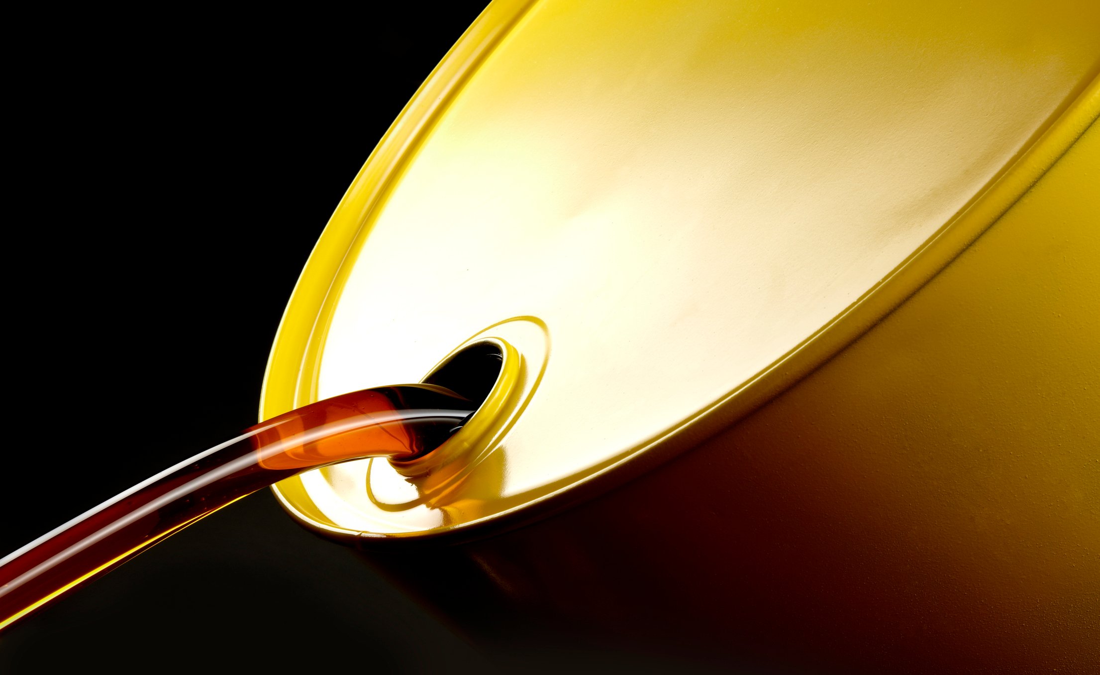 Oil pours from a golden oil drum.