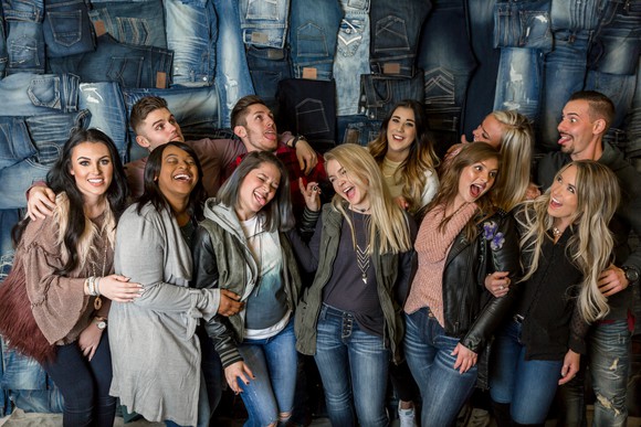 Managers at The Buckle stand in front of a denim display.