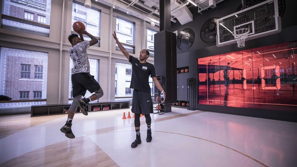 Two people playing basketball inside a Nike store