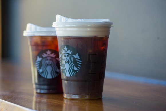 Two Starbucks cold drink cups with strawless lids.