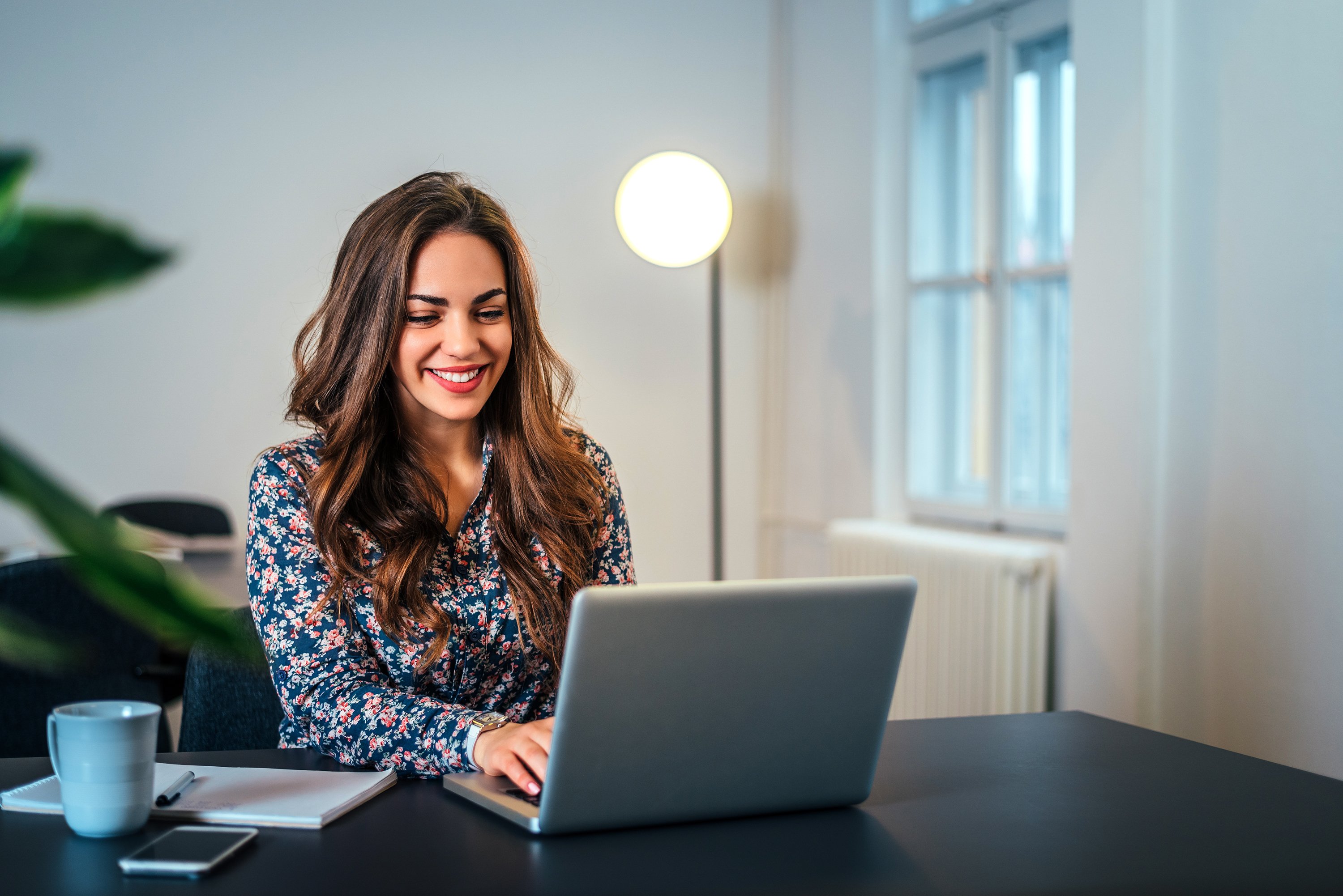 Smiling woman typing on laptop