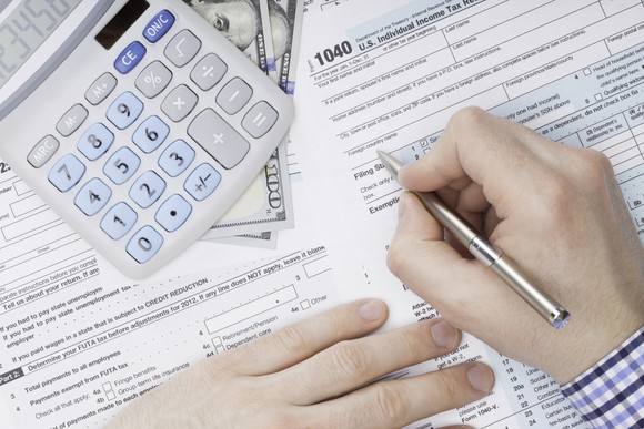 Person filling out tax forms.