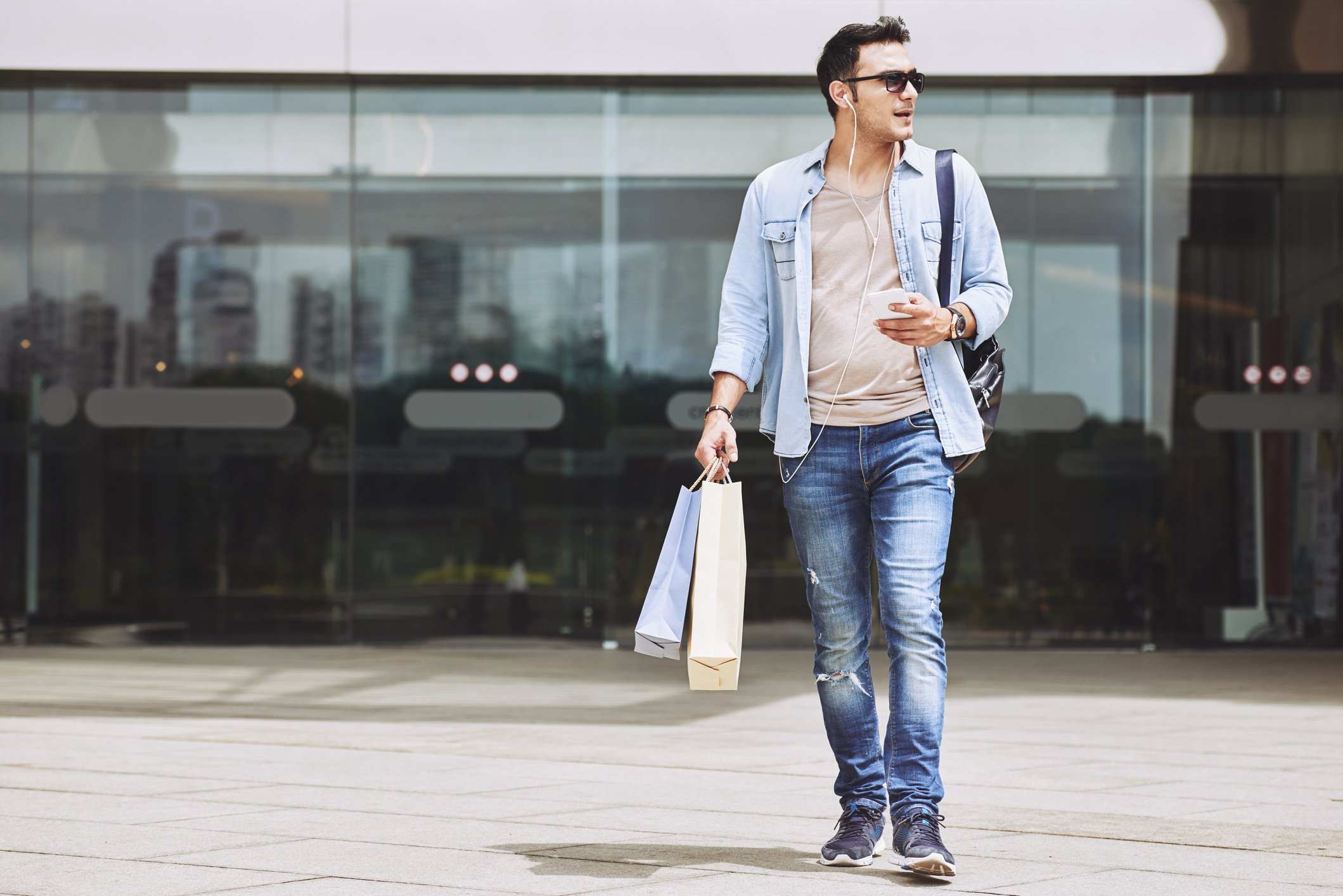 Man leaving shopping mall carrying bags