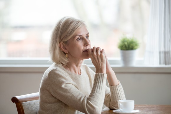 Nervous older woman sitting at a table