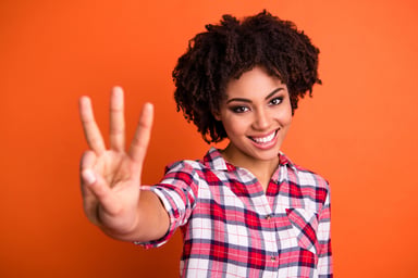 Young woman holding up three fingers