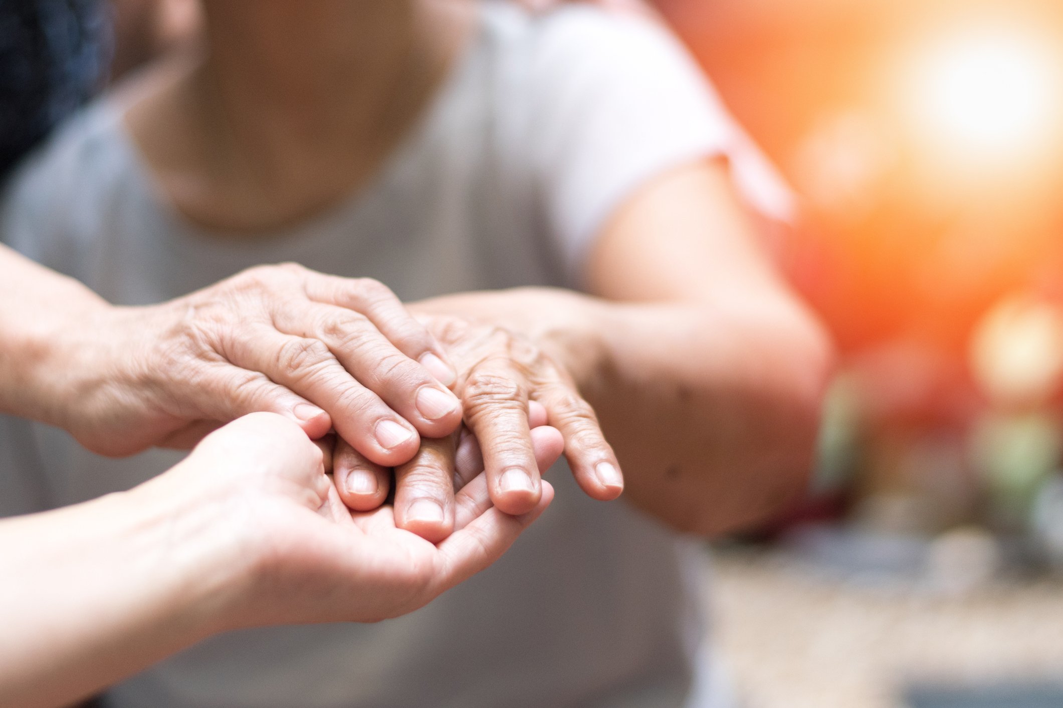 Someone holding an outstretched hand of an elderly patient.
