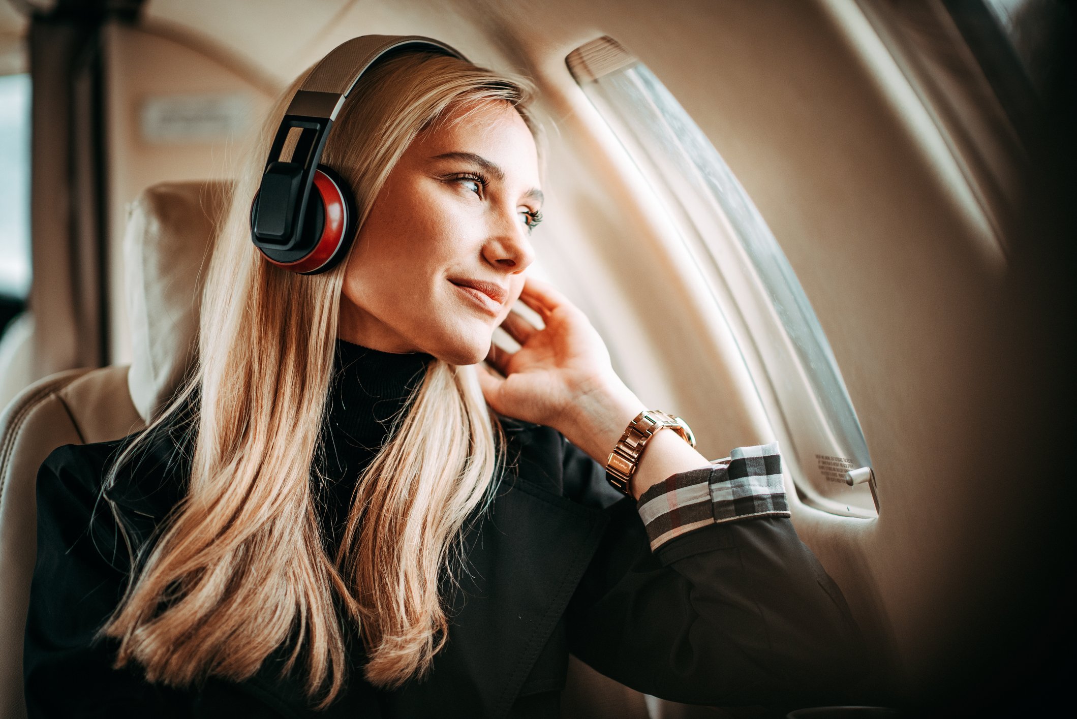 A woman gazes out of an airplane window.