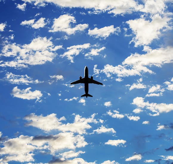 A view from below looking up at an aircraft in a cloudy sky.