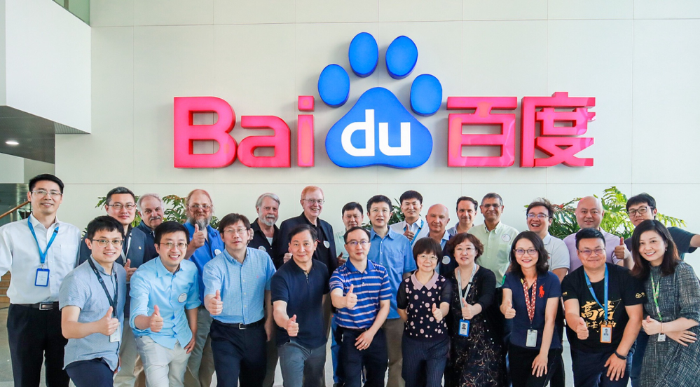 Online researchers posing in front of Baidu's corporate logo.