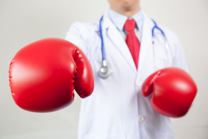 A doctor wearing large, red boxing gloves.