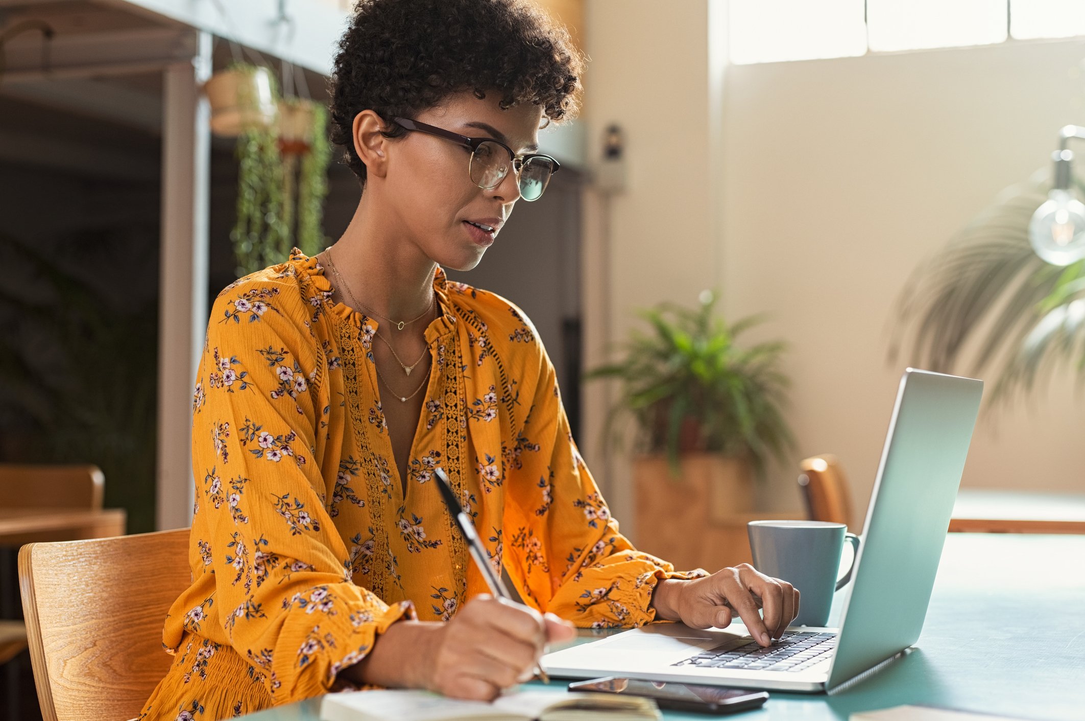 A woman taking notes at her laptop