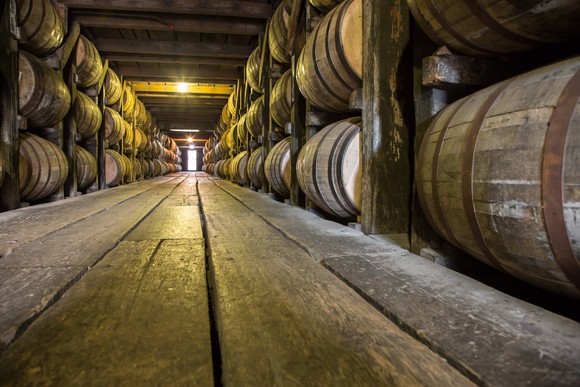 Barrels of aged whiskey in a warehouse.