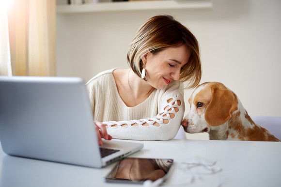 Woman working at home with her dog.
