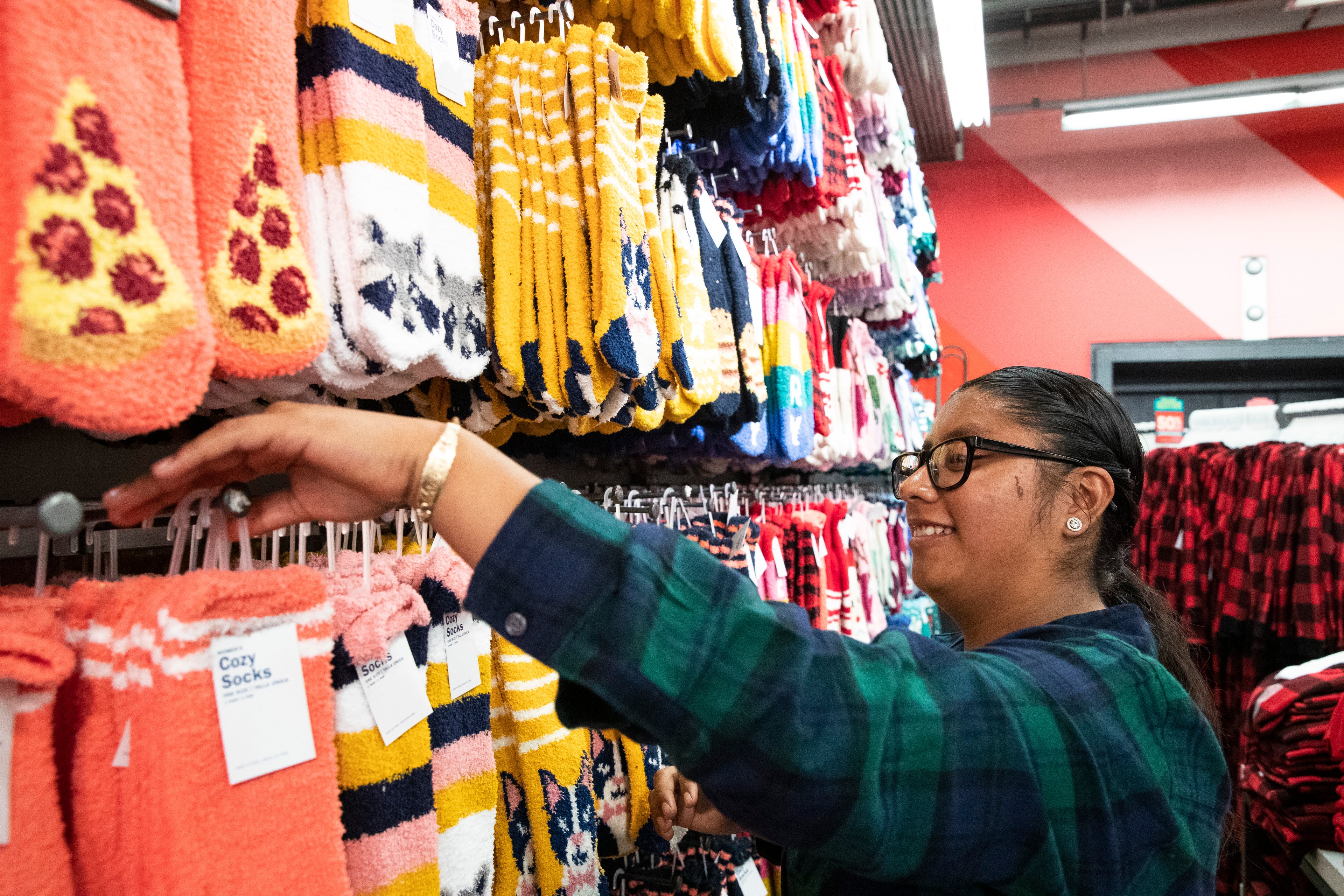 An Old Navy Employee puts socks on the shelves.