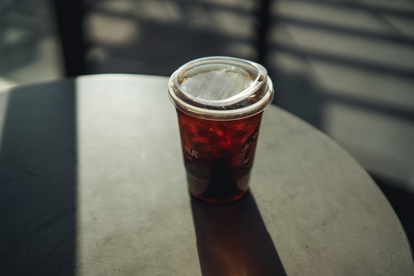 A plastic Starbucks cup with a lid resembling a toddler's sippy cup