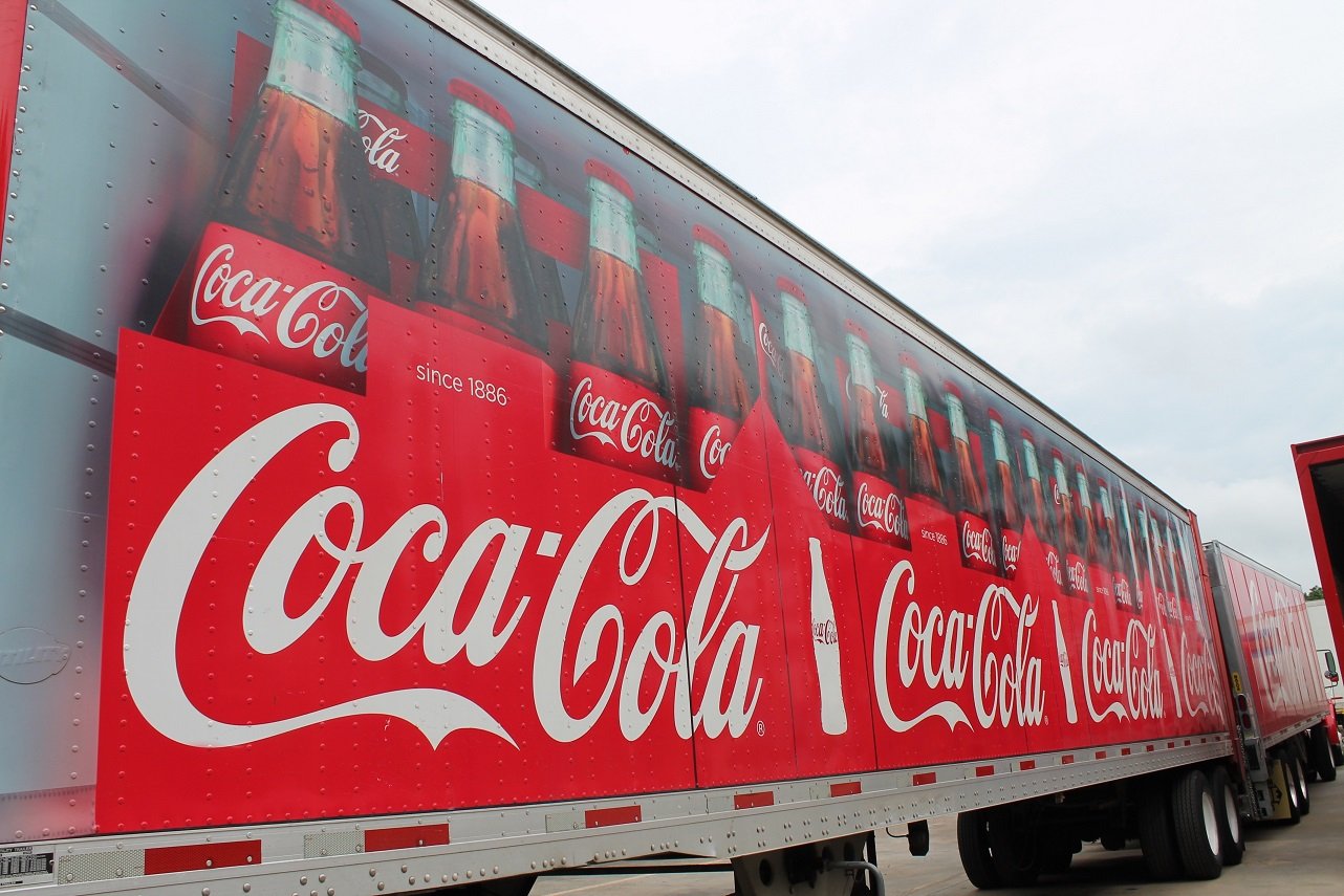 Semi tractor trailer with pictures of Coca-Cola bottles on them.