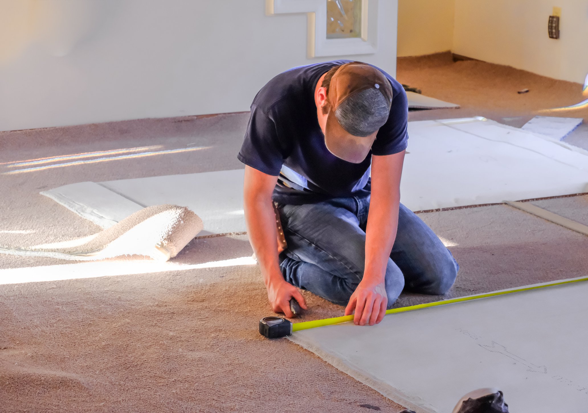A flooring installer works in a residence.