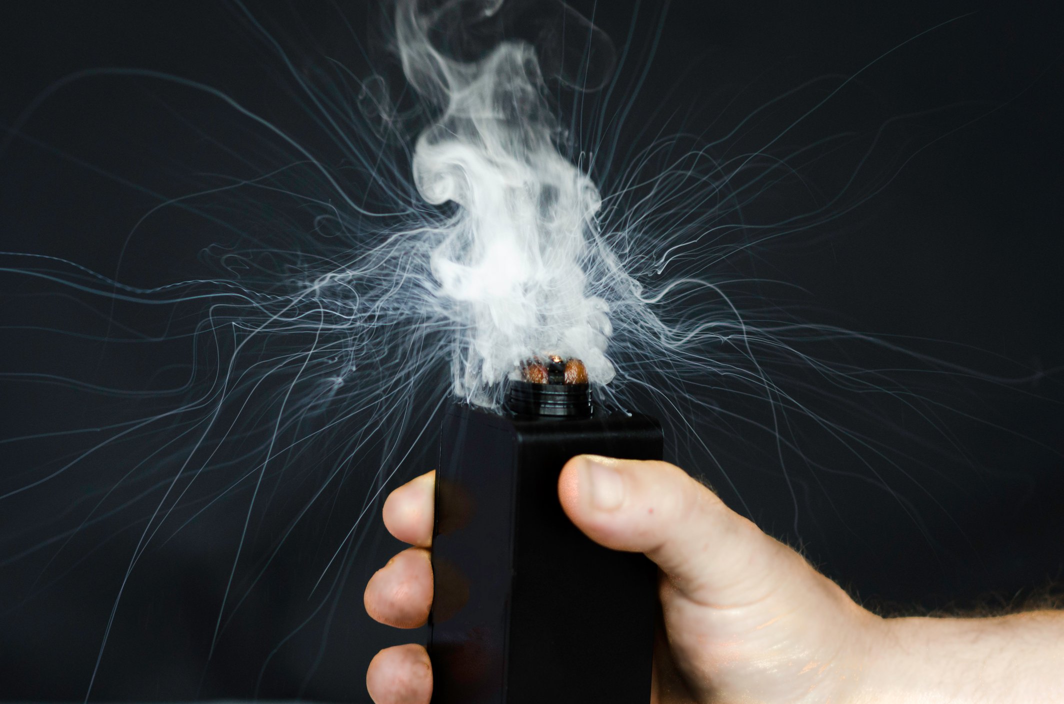 A hand activating a vaporizer.