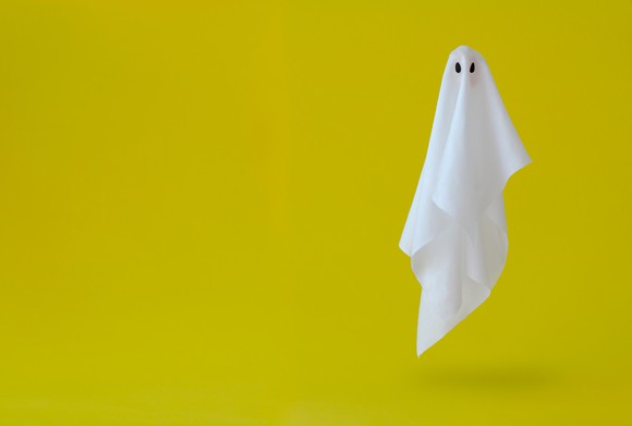 A ghost-shaped sheet hovering against a yellow-orange background