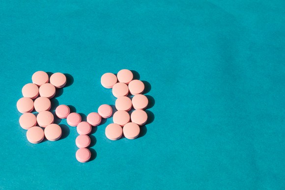 Pills in shape of kidneys on blue background