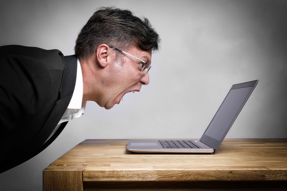 Man screaming at a laptop on a table