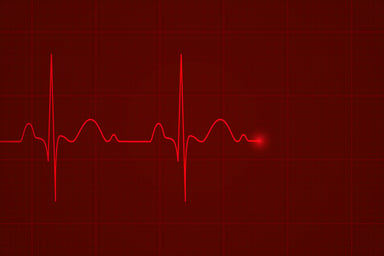 Glowing red heartbeat monitor graph flatlines