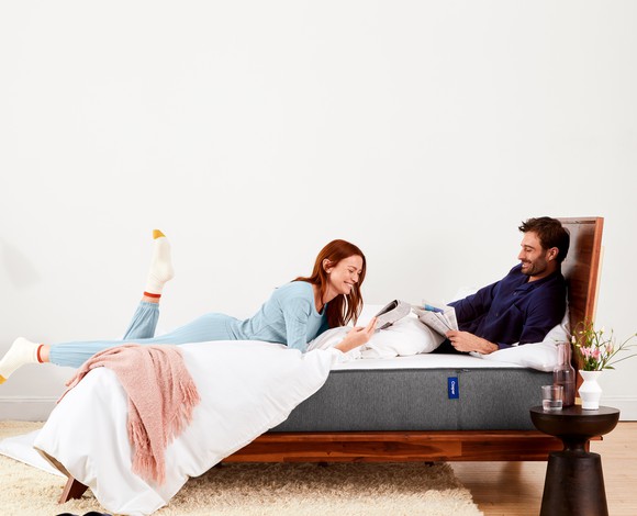 A man and woman relaxing on a Casper mattress.