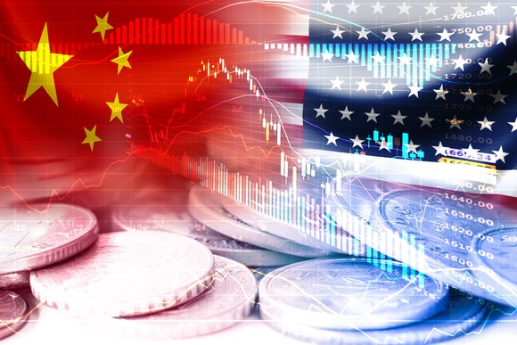 China and U.S. flags superimposed over coins and stock charts.