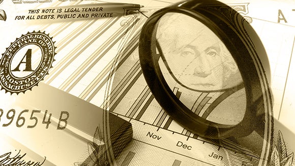 Magnifying glass on a dollar bill and some stock results