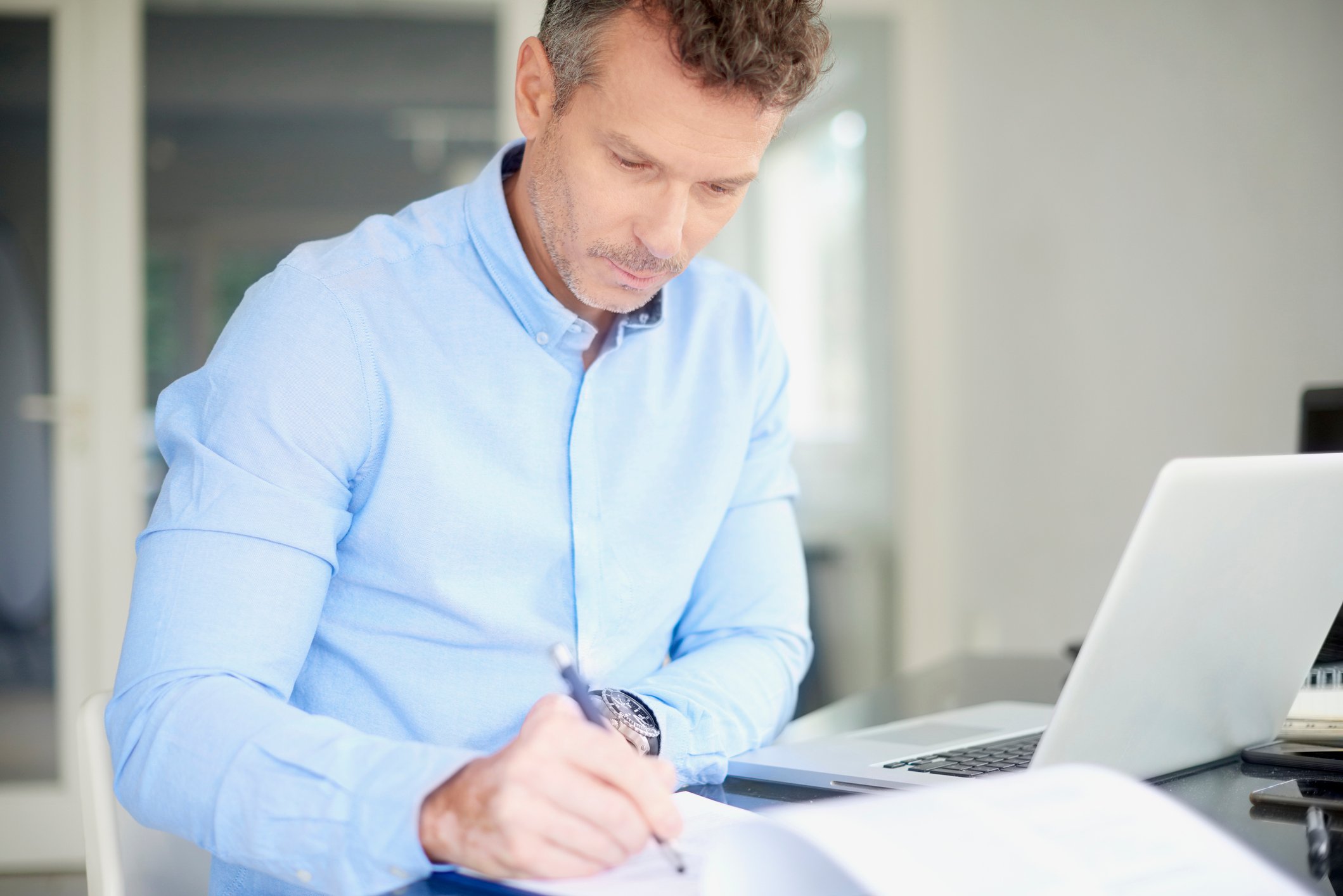 Man at laptop taking notes