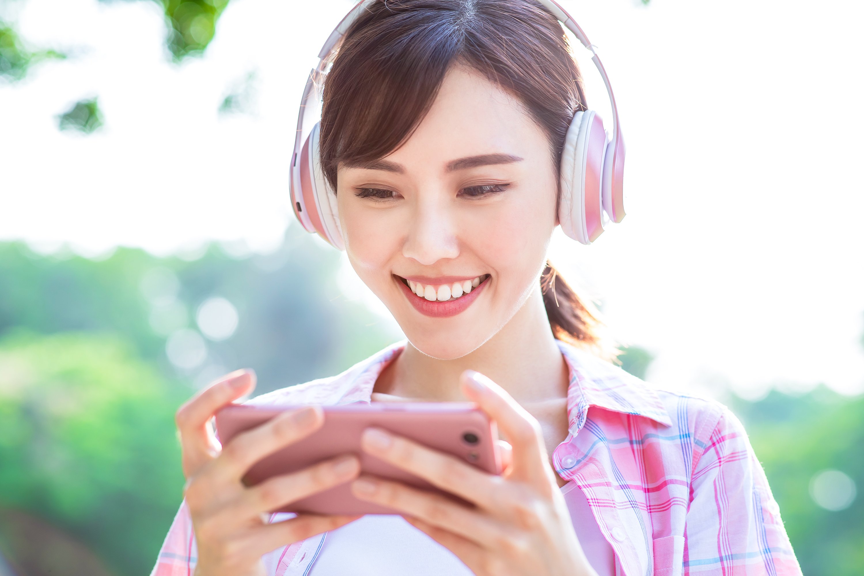 A young woman plays a smartphone game.