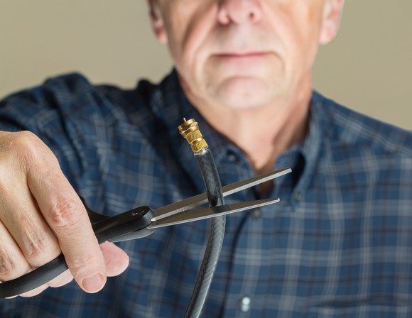 Man cutting cable wire with scissors